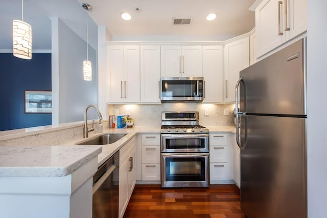 kitchen with a sink, appliances with stainless steel finishes, white cabinetry, and visible vents