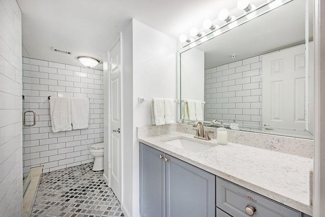 full bathroom featuring toilet, tile patterned floors, tile walls, visible vents, and a stall shower