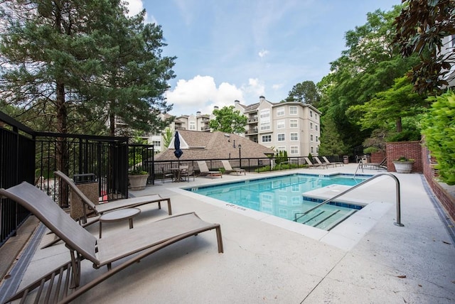pool with fence and a patio area