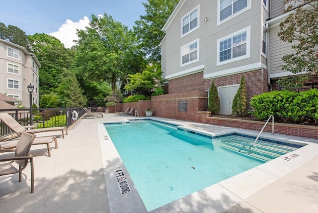 pool with fence and a patio area