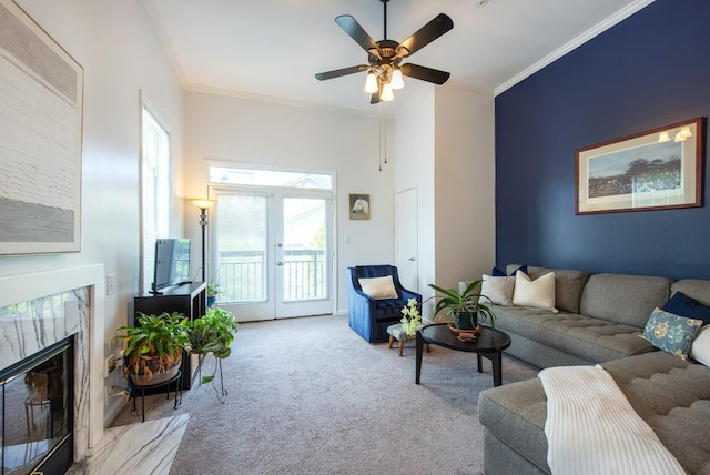 carpeted living room featuring french doors, ornamental molding, a ceiling fan, and a premium fireplace