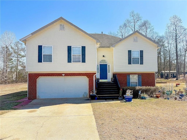 split foyer home featuring driveway, brick siding, and an attached garage