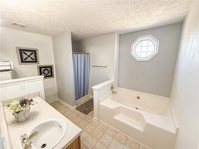 full bath with a bath, visible vents, a textured ceiling, and vanity