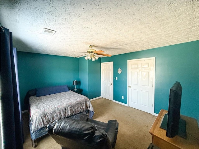 carpeted bedroom with a closet, a textured ceiling, baseboards, and a ceiling fan
