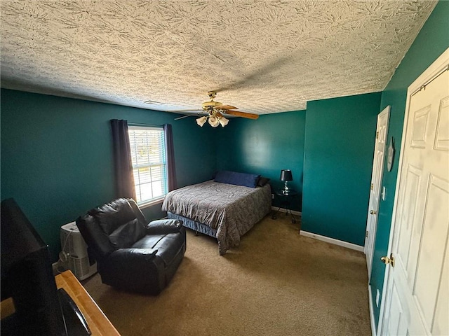 bedroom featuring ceiling fan, a textured ceiling, carpet, and baseboards