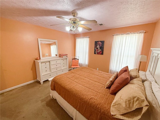 bedroom featuring visible vents, a ceiling fan, carpet flooring, a textured ceiling, and baseboards