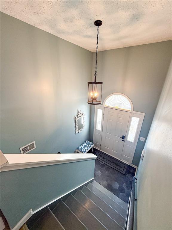 entrance foyer with dark wood finished floors and a textured ceiling