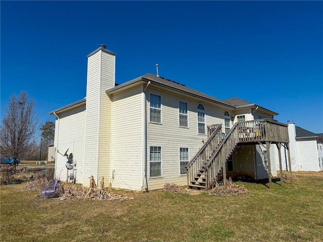 rear view of property with a chimney, stairway, a lawn, and a wooden deck