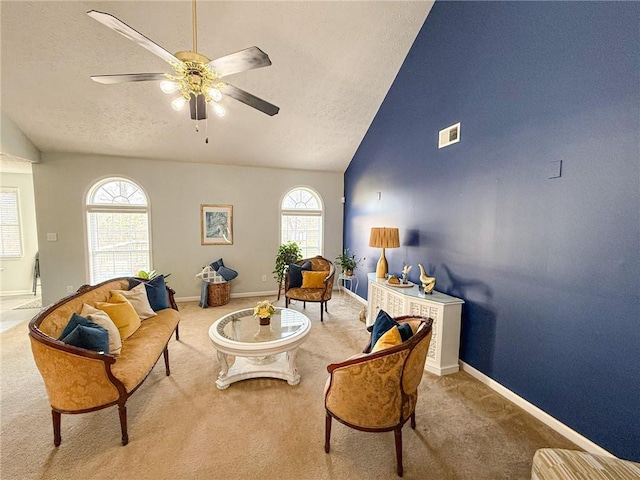 living area featuring a wealth of natural light, visible vents, a textured ceiling, and carpet flooring