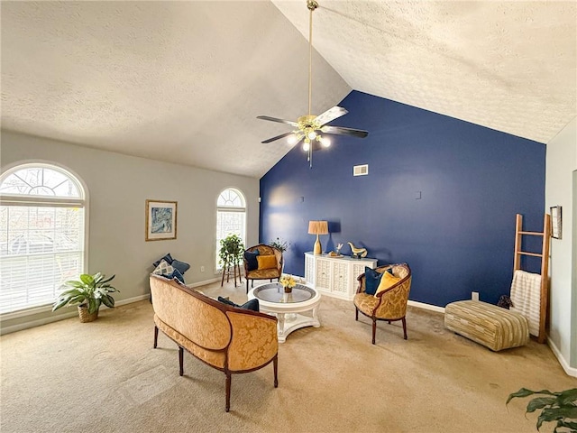 living area featuring carpet, lofted ceiling, visible vents, a ceiling fan, and a textured ceiling