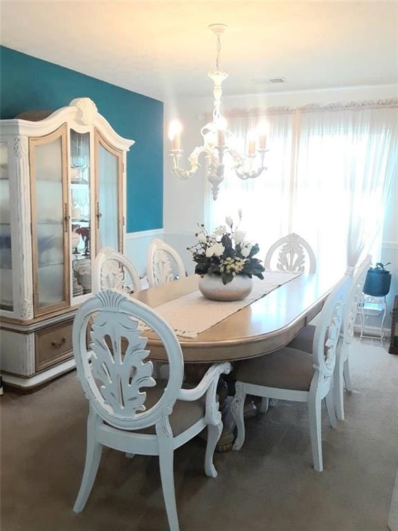 dining room featuring carpet flooring and an inviting chandelier