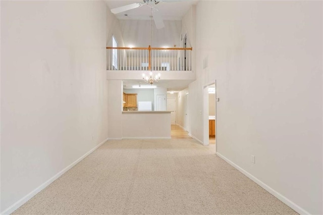 184 Darbys Crossing Ct, Hiram, GA 30141 - unfurnished living room with a chandelier, carpet flooring, ceiling fan, baseboards, and a towering ceiling