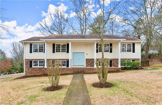 bi-level home featuring brick siding and a front yard