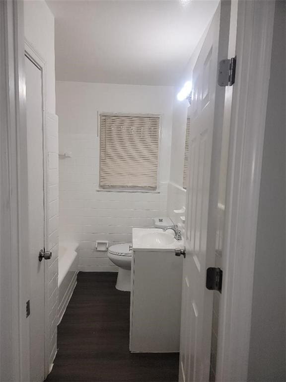 bathroom with toilet, vanity, and hardwood / wood-style flooring