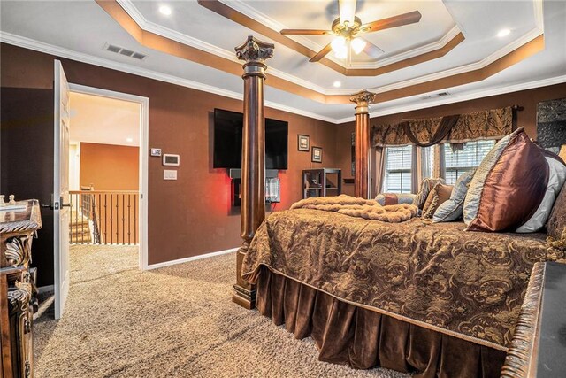 carpeted bedroom with ornamental molding and a tray ceiling