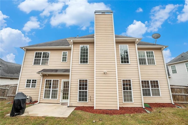 back of house with a lawn and a patio area