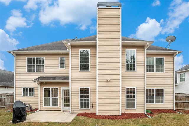 back of property featuring a patio and a lawn