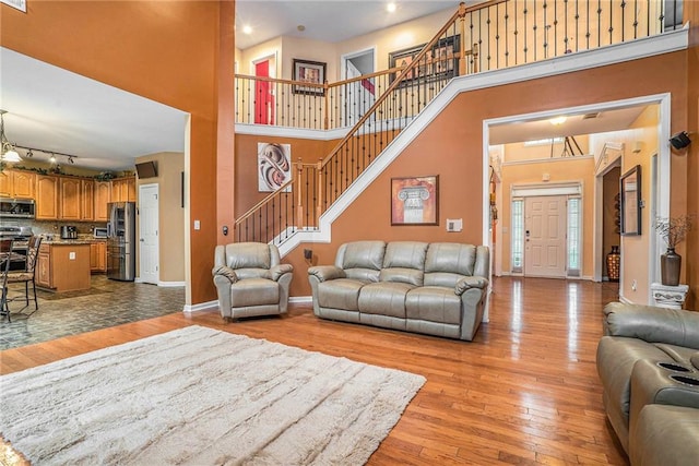 living room featuring light hardwood / wood-style flooring and a towering ceiling