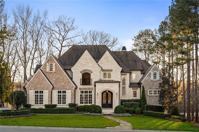 view of front of property featuring french doors and a front lawn