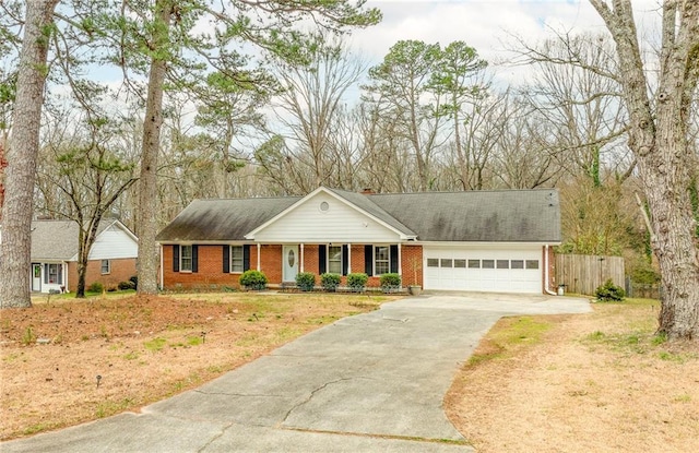 view of front of home with brick siding, a chimney, fence, a garage, and driveway