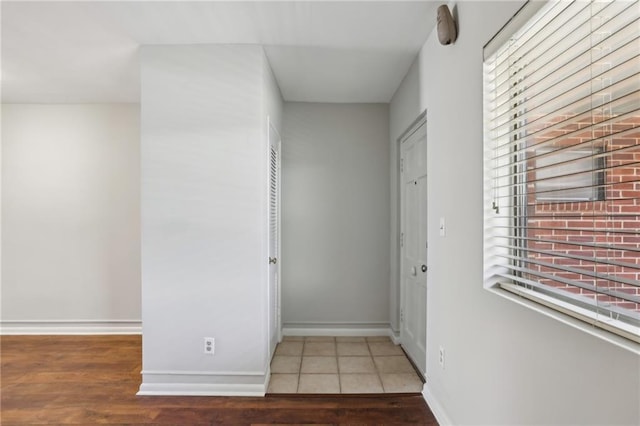 hallway with baseboards and wood finished floors