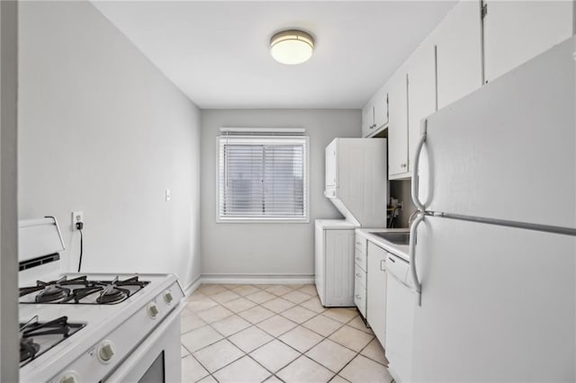 kitchen with light tile patterned floors, light countertops, white cabinetry, white appliances, and baseboards