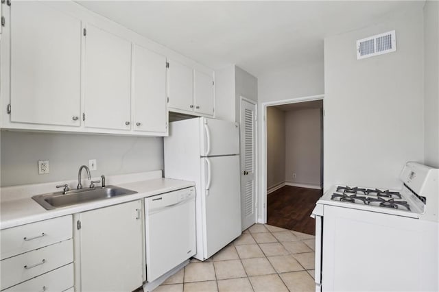 kitchen featuring light countertops, visible vents, white cabinetry, a sink, and white appliances