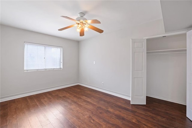 unfurnished bedroom with dark wood-style floors, a closet, baseboards, and a ceiling fan