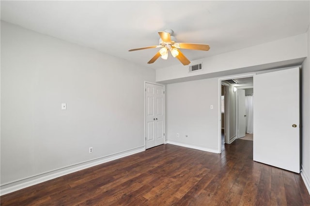 unfurnished bedroom featuring visible vents, a ceiling fan, attic access, wood finished floors, and baseboards