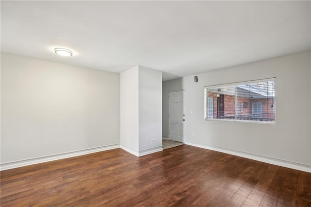 unfurnished room featuring baseboards and wood finished floors