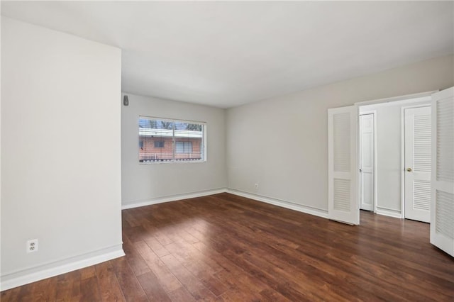 unfurnished room featuring baseboards and wood finished floors