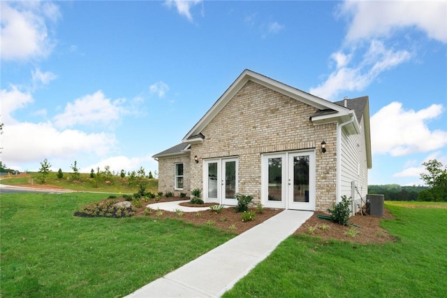 back of house with french doors, a yard, and central air condition unit