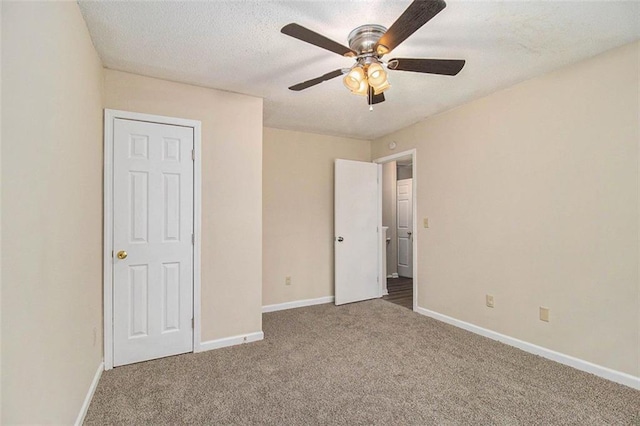 unfurnished bedroom featuring a textured ceiling, ceiling fan, carpet, and baseboards