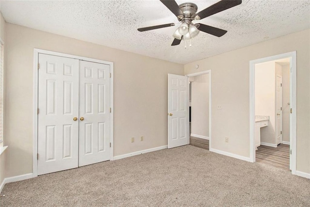 unfurnished bedroom featuring a closet, carpet flooring, ceiling fan, a textured ceiling, and baseboards