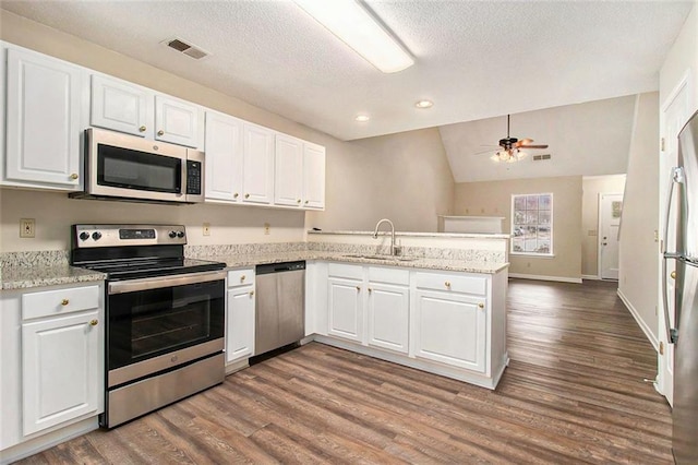 kitchen featuring a peninsula, white cabinetry, appliances with stainless steel finishes, and a sink