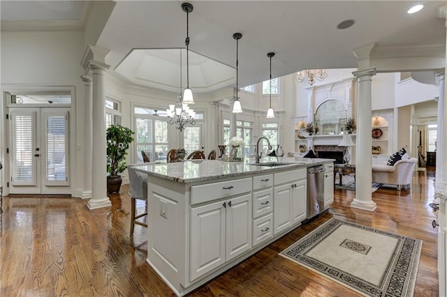 kitchen with a fireplace, a chandelier, stainless steel dishwasher, and a sink