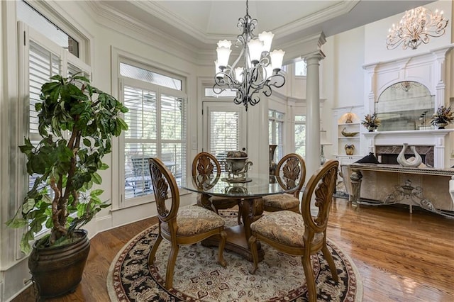 dining space featuring a high ceiling, crown molding, wood finished floors, and a chandelier