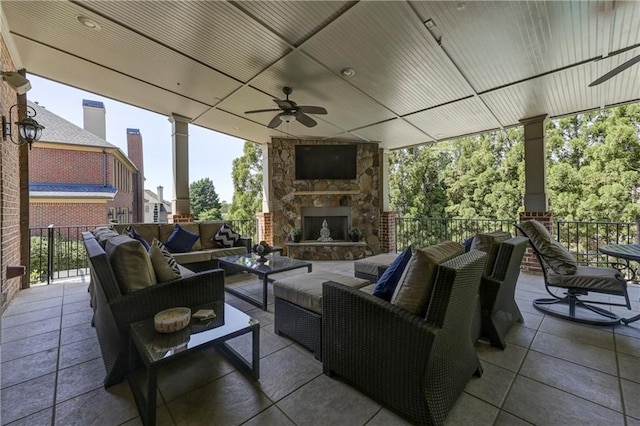 view of patio with an outdoor living space with a fireplace, a ceiling fan, and fence