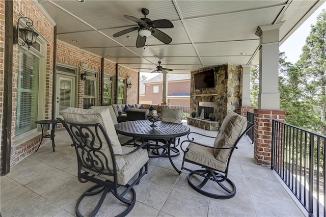 view of patio / terrace featuring an outdoor living space with a fireplace and a ceiling fan