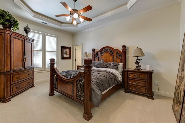 bedroom with a tray ceiling, visible vents, light carpet, crown molding, and baseboards