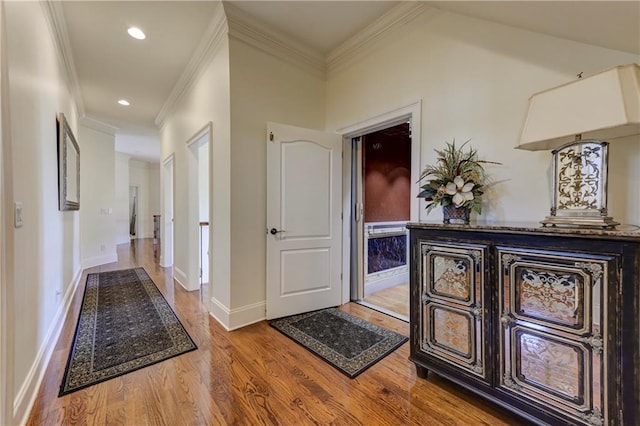 hallway featuring recessed lighting, wood finished floors, baseboards, and ornamental molding