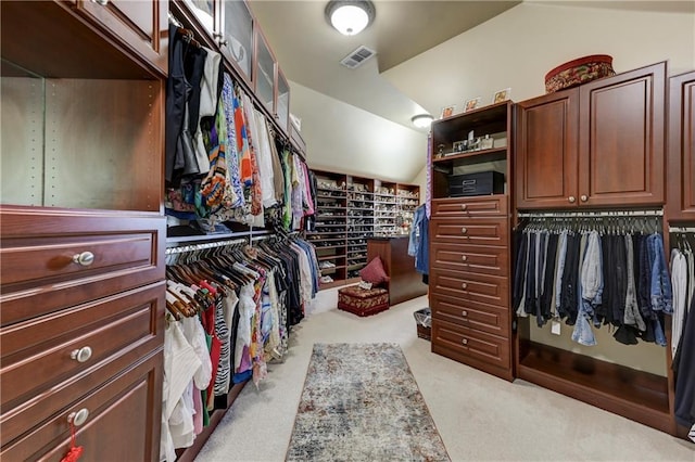spacious closet with vaulted ceiling, visible vents, and carpet