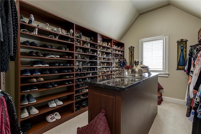 wine area with light carpet, vaulted ceiling, and baseboards
