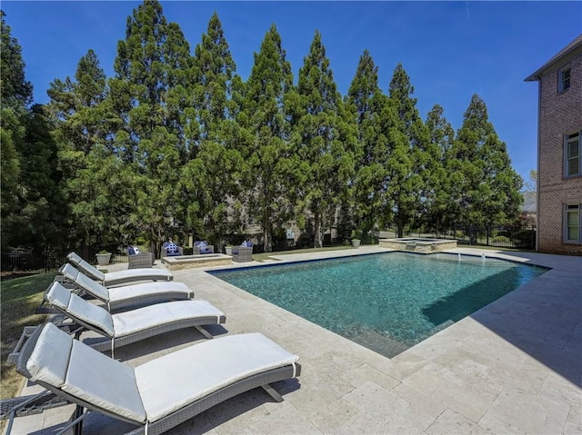 pool with a patio and an in ground hot tub