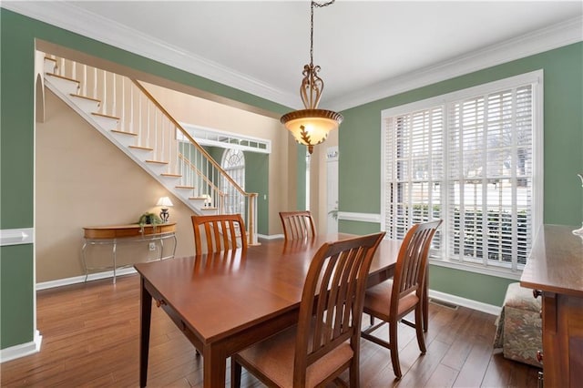 dining space with crown molding and dark hardwood / wood-style flooring