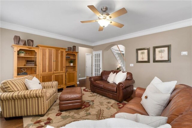 living room featuring ornamental molding, light wood-type flooring, ceiling fan, and a high end fireplace