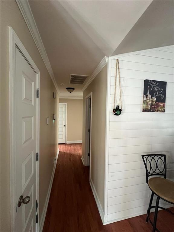 corridor with dark hardwood / wood-style floors and crown molding