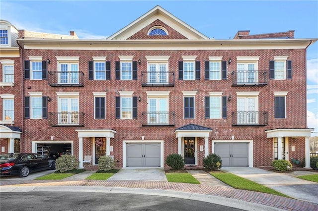 multi unit property featuring driveway, brick siding, and an attached garage