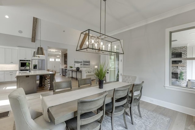 4781 Falling Brook Dr, Flowery Branch, GA 30542 - dining space featuring light wood-style floors, plenty of natural light, baseboards, and a chandelier
