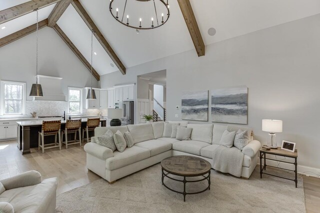 4781 Falling Brook Dr, Flowery Branch, GA 30542 - living room featuring light wood-style floors, beamed ceiling, high vaulted ceiling, and a chandelier